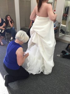 Wedding planner helping bride with dress