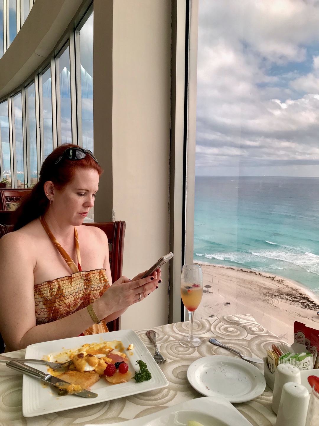 woman looking at menu at table at oceanfront restaurant