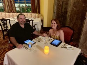 man and woman holding hands at dinner table