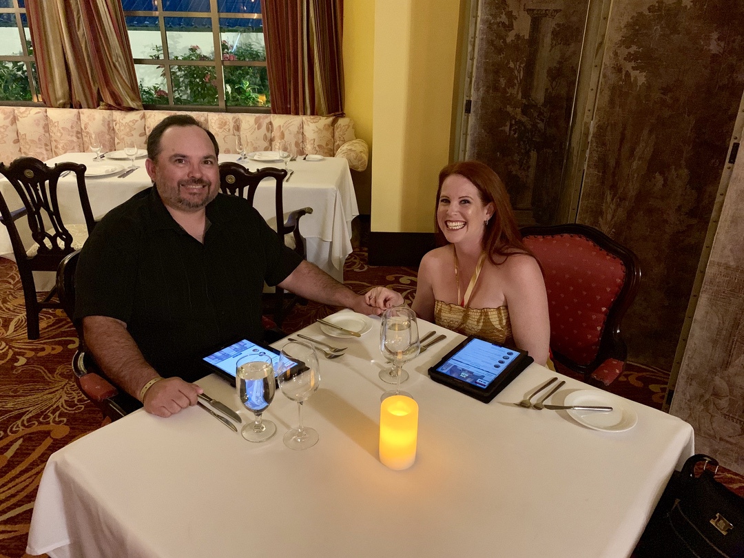 man and woman holding hands at dinner table