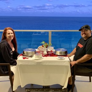 man and woman on balcony with dinner