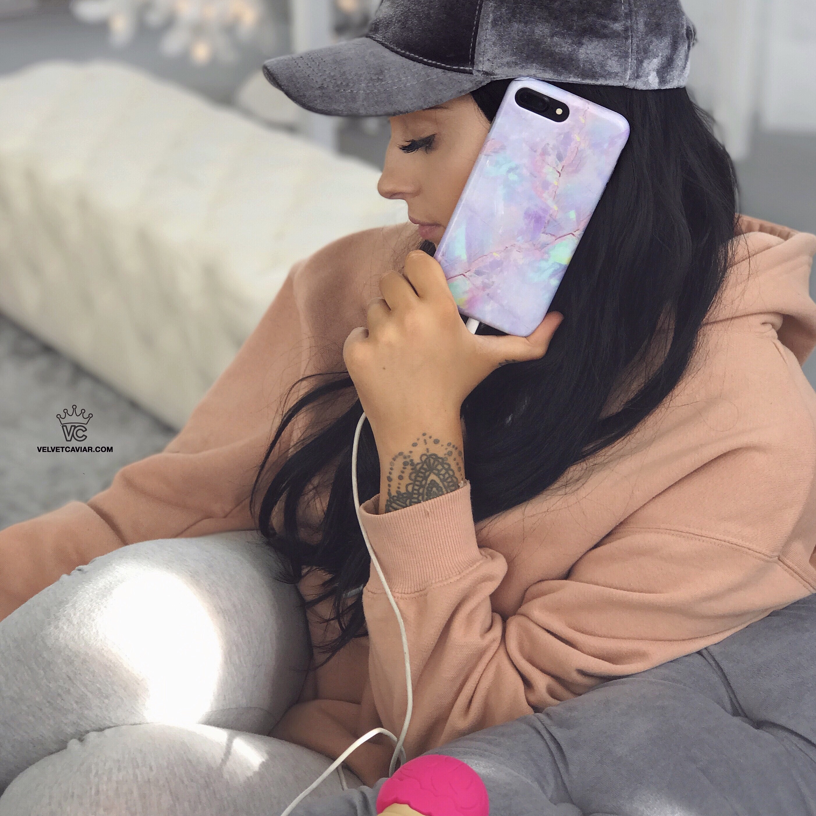 a woman sitting in a chair holding phone with glass cover