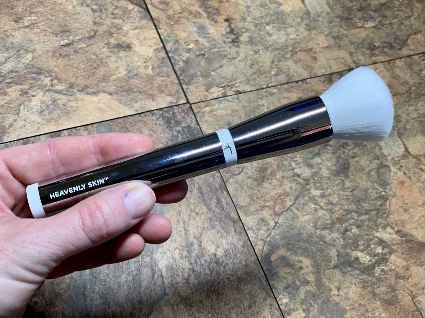 A hand holding a makeup brush