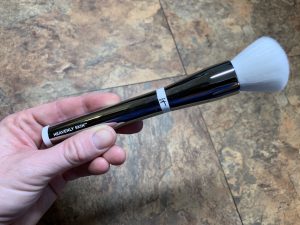 A hand holding a makeup brush