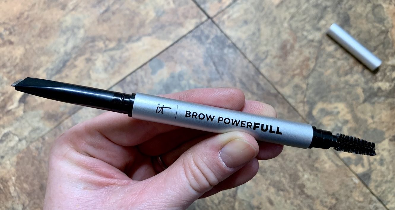 A hand holding an eyebrow pencil