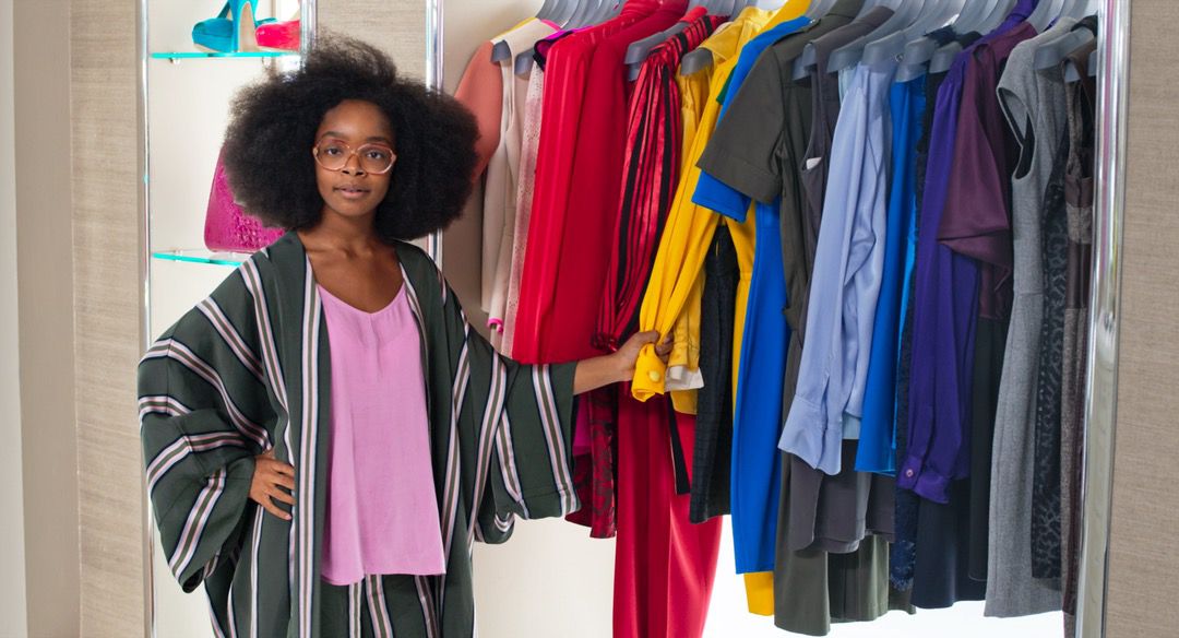 girl with glasses in closet with clothes