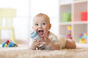 baby on tummy on floor with bottle