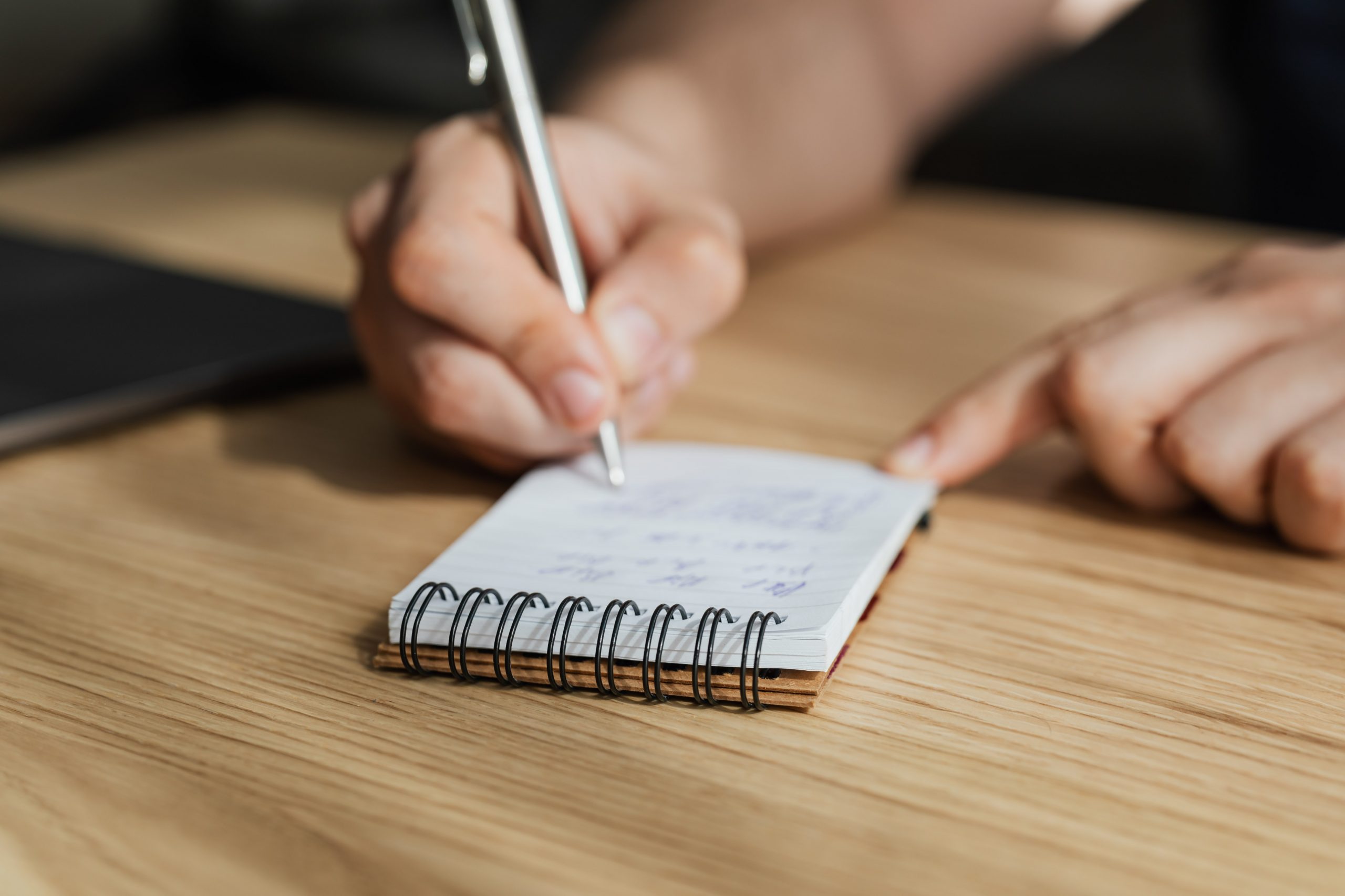 hand holding pen and notepad