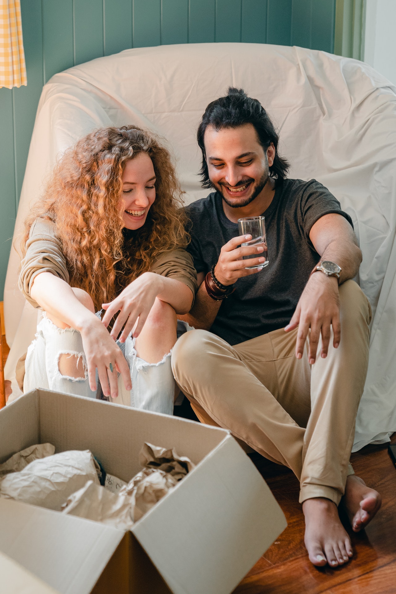 couple Drinking over packed boxes from moving