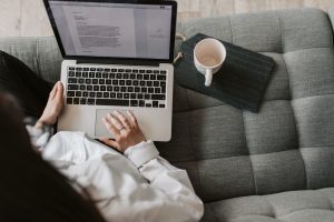 woman laptop hand couch coffee