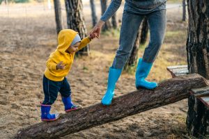child with parent on log