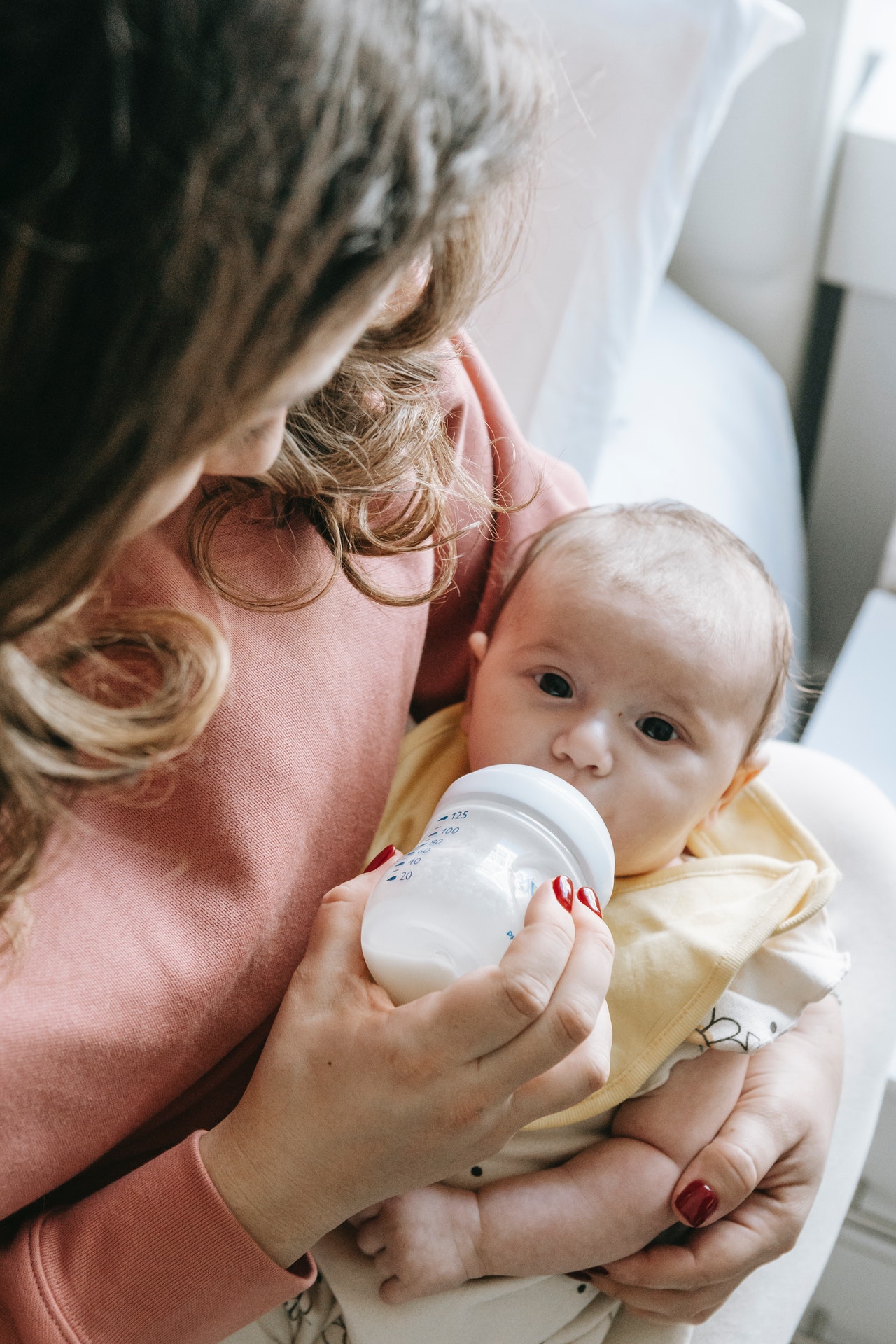 baby drinking bottle of formula