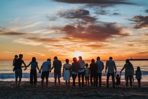 family together holding hands on beach