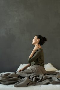 woman with neck pain on bed