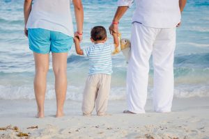 mom dad and child on beach