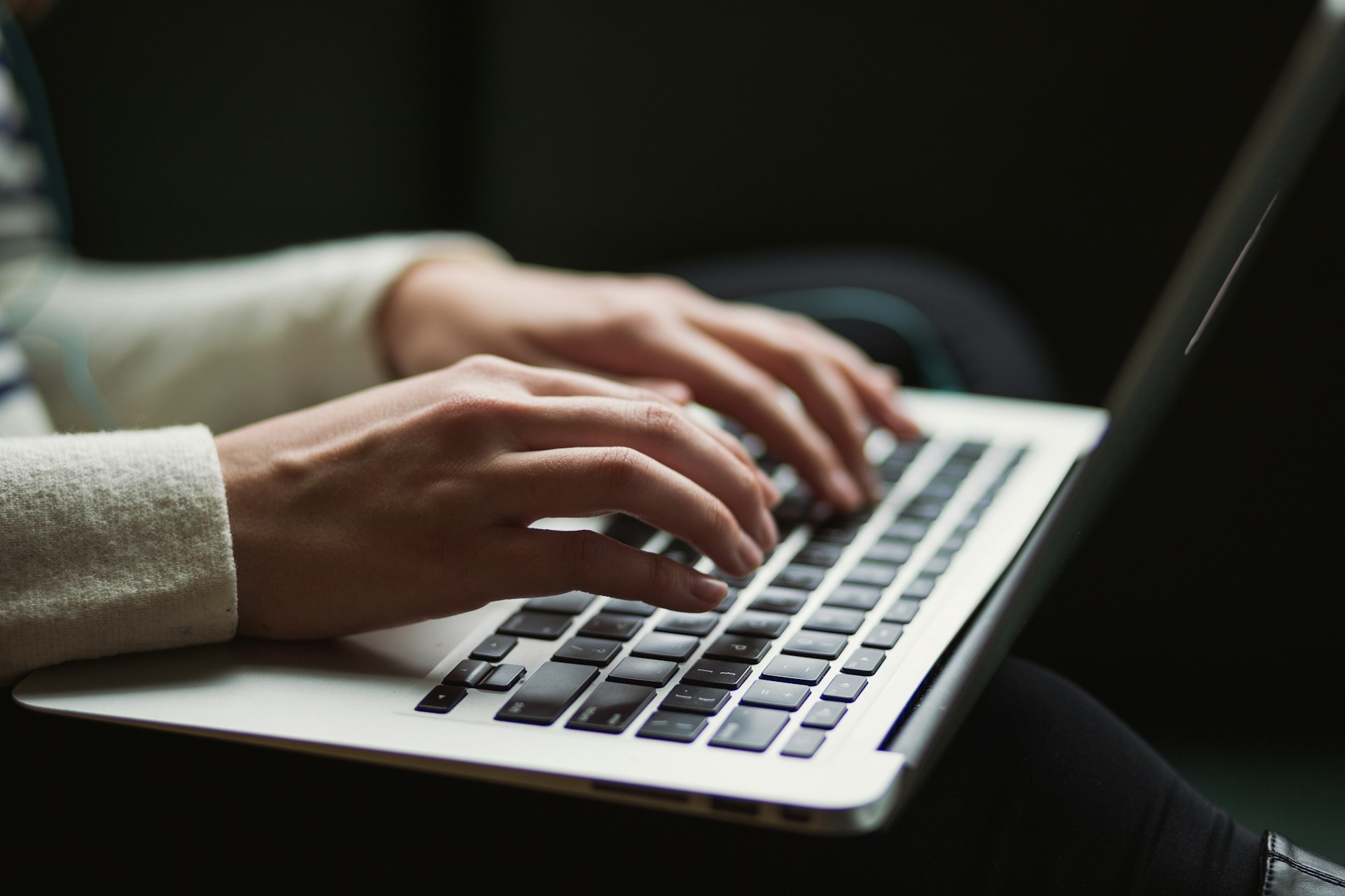 hands typing on laptop - link shorteners for content sharing