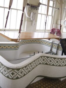 A bedroom with a bed and a chair in a room