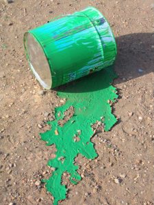 A spilled green paint can