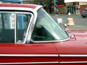 A red car parked on the side of a building
