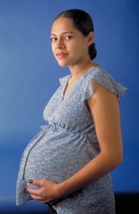 A woman pregnant in a blue shirt
