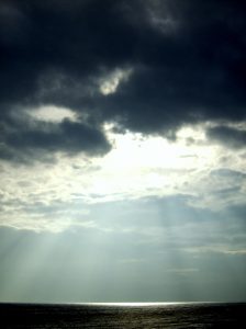 A group of clouds in the sky sun shining through