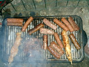 A bunch of hot dogs cooking on a grill