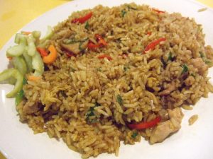 A plate of food with rice meat and vegetables